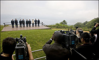 Photographers train their lenses on the G-8 leaders Tuesday, July 8, 2008, as they pose for the official family photograph in Toyako, Japan. In the background is Lake Toya.