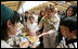 Mrs. Laura Bush tastes a sampling of the food at the Hokkaido Marche farmer's market in Makkari Village Tuesday, July 8, 2008, as part of the G-8 Spouses Program. The small village on the northern Japanese island of Hokkaido is known for its lilies and its potatoes, and the market, organized especially for the occasion of the G-8 Summit, showcased locally grown produce.