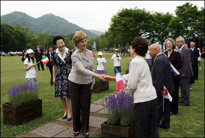 Mrs. Laura Bush, accompanied by Mrs. Kiyoko Fukuda, spouse of the Prime Minister of Japan, left, is greeted as she arrives to the Toyako New Mount Showa Memorial Park for a ceremonial tree planting ceremony with other G-8 spouses Wednesday, July 9, 2008, in Hokkaido, Japan.