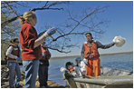 White House Intern Dee Moore tosses a bag of collected trash to Chad Pregracke, founder of Living Lands and Waters. As part of a service project, White House Interns spent several hours cleaning the banks of the Potomac River Thursday, April 13, 2005.