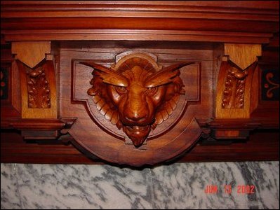 The stylized lion's head over the room's fireplace. 