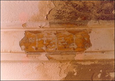 Evidence of the painted decoration on the wood molding in room 231.