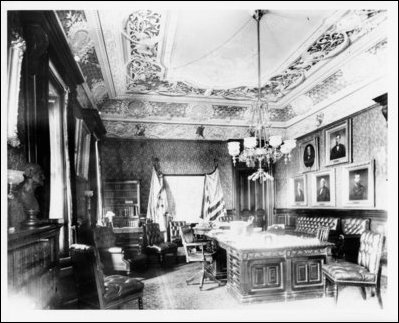 1888 view north in the Secretary of War's Reception Room showing the original light fixture, the Lincrusta Walton wall covering, and the image on the ceiling of Mars in his chariot pulled by two horses.