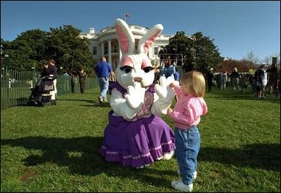 Enjoying the sunny day, a young visitor at the White House Easter Egg Roll meets one of the Easter bunnies on the South Lawn, Monday, April 1, 2002. 