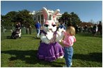 Enjoying the sunny day, a young visitor at the White House Easter Egg Roll meets one of the Easter bunnies on the South Lawn, Monday, April 1, 2002. 