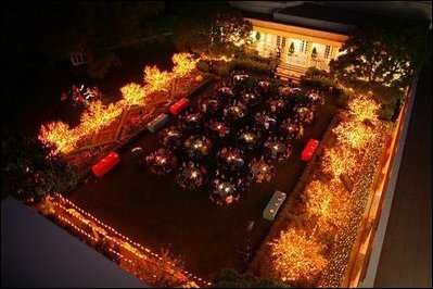 As night falls, the Rose Garden is filled with the glow of lighted trees as members of the Marine Band serenade President George W. Bush and Laura Bush and their guests during a dinner celebrating Cinco de Mayo Wednesday, May 4, 2005.