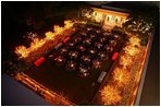 As night falls, the Rose Garden is filled with the glow of lighted trees as members of the Marine Band serenade President George W. Bush and Laura Bush and their guests during a dinner celebrating Cinco de Mayo Wednesday, May 4, 2005.