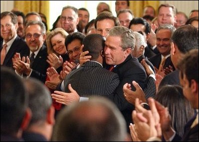 President George W. Bush embraces Brazilian Musician Alexandre Pires after his performance during the Celebration of Hispanic Heritage Month in the East Room, Thursday, Oct 2, 2003.