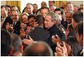 President George W. Bush embraces Brazilian Musician Alexandre Pires after his performance during the Celebration of Hispanic Heritage Month in the East Room, Thursday, Oct 2, 2003.
