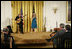 President George W. Bush, seated right-front, listens to the performance of singer Ana Cristina and guitarist Marco Linares, Friday, Oct. 6, 2006, in the East Room of the White House, in celebration of National Hispanic Heritage Month.
