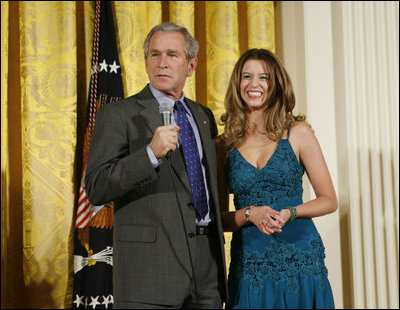 President George W. Bush joins singer Ana Cristina on stage to thank her and guitarist Marco Linares for their performance Friday, Oct. 6, 2006, in the East Room of the White House, in celebration of Hispanic Heritage Month.