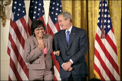 President George W. Bush stands with Volunteer Service Award recipient Maria Hines of Albuquerque, N.M., in the East Room of the White House, Friday, Oct. 7, 2005, where President Bush honored six recipients of the President's Volunteer Service Awards, as part of the celebration of Hispanic Heritage Month.