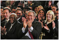 President George W. Bush applauds during the Celebration of Hispanic Heritage Month in the East Room, Thursday, Oct 2, 2003. Also pictured from left are, Tony Garza, U.S. Ambassador to Mexico and Pedro Knight, the husband of late singer Celia Cruz.