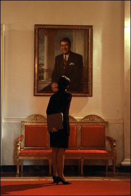 In between meetings, National Security Adviser Condoleezza Rice studies a portrait of President Ronald Reagan in the Cross Hall on Feb. 13, 2002.