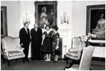 President Dwight Eisenhower and Mamie Eisenhower receive a donation of antique furniture for the Diplomatic Reception Room of the White House on June 29, 1960. The Federal style furniture includes a pale gold silk sofa and matching chairs. Joining the Eiswenhowers are Michael Greer of the National Society of Interior Designers, Inc. and designer Dora Brahms.