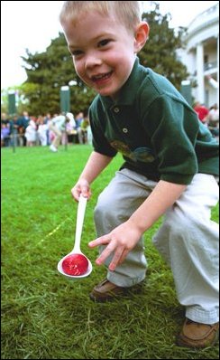 A young competitor shows off his slightly-cracked, but still intact hard-boiled Easter egg after rolling it through the South Lawn race course during the White House Easter Egg Roll Monday, April 21, 2003. 