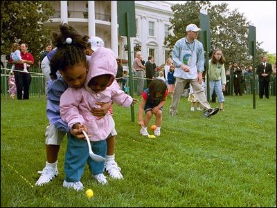 A helping hand is given during the Easter egg roll where little competitors use a spoon to carry a hard-boiled egg through the South Lawn race course and across the finish line at the White House Easter Egg Roll Monday, April 21, 2003. 