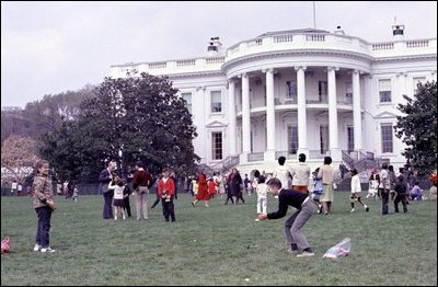 Two kids toss eggs on the South Lawn of the White House at the 1966 Easter Egg Roll. Such Games as "Egg Picking," "Egg Ball," "Toss and Catch," and "Egg Croquet" began near the end of the nineteenth century at the White House Easter Egg Roll.