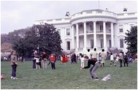 Two kids toss eggs on the South Lawn of the White House at the 19XX Easter Egg Roll. Such Games such as "Egg Picking," "Egg Ball," "Toss and Catch," and "Egg Croquet" began near the end of the nineteenth century at the White House Easter Egg Roll.