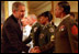 With a portrait of America's first General and first President hanging in the background, President George W. Bush and Defense Secretary Donald Rumsfeld congratulate military re-enlistees in an event held in the East Room May 23, 2001. Congress purchased the portrait of George Washington by Gilbert Stuart for the White House in 1800.