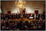Joined by members of Congress and 15 American families in the East Room June 7, 2001, President George W. Bush signs the Tax Relief Act, which provides Americans with across-the-board tax cuts. 