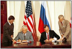 Side by side, President George H.W. Bush and Russian President Yeltsin sign seven trade treaties in the East Room June 17, 1992. The treaties removed barriers to trade that had evolved during the Cold War. The United States also granted Russia most-favored-nation status in trade relations for the first time in more than four decades.