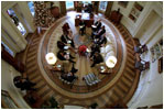 President George W. Bush hosts a meeting with senior advisers in the newly-renovated Oval Office, which includes a specially-designed wool rug featuring the Presidential coat of arms Dec. 20, 2001. The color scheme of the first Oval Office, built in 1909 during the Taft Administration, was olive green.