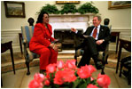 President George W. Bush and Coretta Scott King, the widow of Dr. Martin Luther King, Jr., share a laugh in the Oval Office Jan. 21, 2002. President George W. Bush honored Dr. King in a White House celebration and received a portrait of the civil rights leader from his wife and children in the East Room.