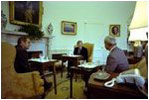 While sitting in front of the fireplace in the Oval Office February 7, 1977, President Jimmy Carter hosts a lunch for Vice President Mondale and energy adviser James Schlesinger. Hanging above the mantel is Charles Willson Peale's portrait of George Washington, which President Carter acquired for the White House's permanent art collection.