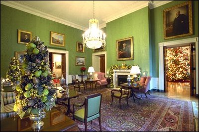 One of the finest pieces of art in the White House, the portrait of Benjamin Franklin by David Martin, is the centerpiece of the Green Room. Topiaries of gold and green fruit stand on either side of the sofa and brilliant red poinsettias and fresh green pears.