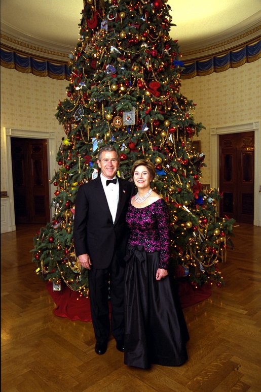 President George W. Bush and Laura Bush stand before the White House Christmas Tree Sunday, Dec. 8, 2002. Mrs. Bush is wearing a floor-length gown designed by Arnold Scaasi. White House photo by Eric Draper.