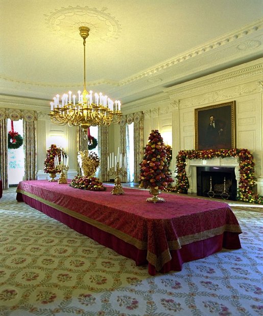 Cheerful garlands and bright sprays of greenery decorate the mantel and cascade from wall sconces in the State Dining Room. Ed and Cindy Hedlund and their son Thomas, of Hedlund Christmas Farm in Elma, Washington presented this year's 18-foot noble fir to President George W. Bush and wife Laura Bush. White House photo by Tina Hager.