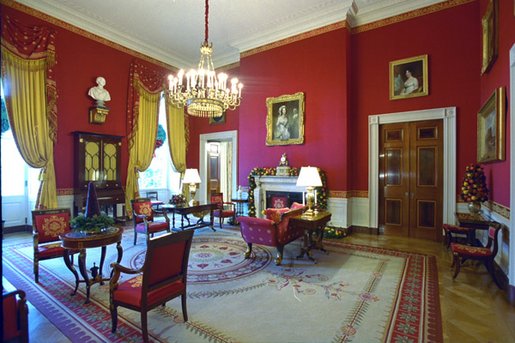 The Red Room is decorated with garlands and topiaries made of pomegranates, pears and magnolia leaves. A small cranberry tree surrounded by holly sits on an antique marble-top table. White House photo by Tina Hager.