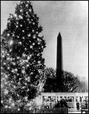 The 1940 National Community Christmas Tree, lit by President Franklin D. Roosevelt, glows in front of the Washington Monument. 