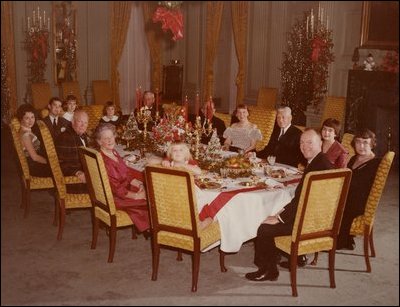 President and Mrs. Eisenhower are all smiles as they host a 1960 Christmas Party in the State Dining Room.