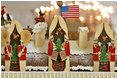 The roof of the White House Gingerbread House is adorned with Santa Claus, his sleigh, and a trio of instruments. The American Flag sits prominently on the roof.