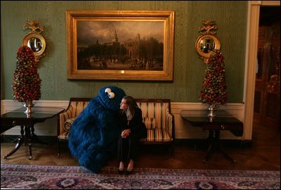 Cookie Monster from Sesame Street sits in the Green Room with a friend while attending the Children's Christmas Reception and Program at the White House, Dec. 6, 2004. The Cookie Monster and other children's television characters sang Christmas songs during the event. 