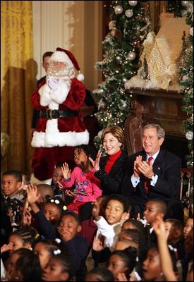 President George W. Bush Laura Bush watch a puppet show and sing Christmas Carols with dozens of school children attending the White House Children's Christmas Program in the East Room, Monday, Dec. 6, 2004. 