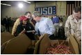 President George W. Bush and Laura Bush visit Operation USO CarePackage at Fort Belvior, Va., Friday, Dec. 10, 2004. "This is one way of saying, America appreciates your service to freedom and peace and our security," said the President in his remarks about the program that has delivered more than 480,000 care packages. 