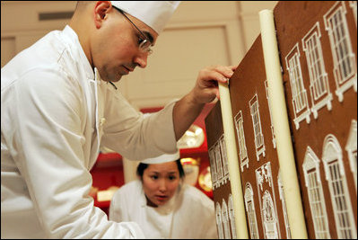 Thaddeus DuBois, Head Pastry Chef, places columns of white chocolate onto of the official White House gingerbread house.