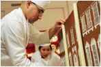 Thaddeus DuBois, Head Pastry Chef, places columns of white chocolate onto of the official White House gingerbread house.