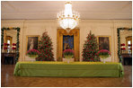 Christmas Trees in the East Room are decorated with roses as the traditional scene of the creche is featured prominently.
