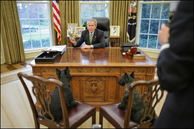 President Bush discusses the true meaning of the holidays with Barney and Miss Beazley in the Oval Office.