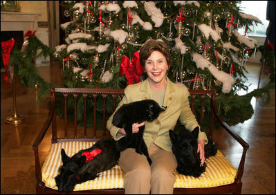 Mrs. Laura Bush poses with Barney, Miss Beazley and the family cat Willie, nicknamed “Kitty,” Friday, Dec. 1, 2006, next to the White House Christmas Tree in the Blue Room.