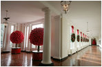 The East Colonnade is lined with wreaths and accented with red, glass ornaments. This year more than 269 wreaths and 4,638 red ornament balls were hung in the White House. Hundreds of the polished glass spheres were used to create shiny tree sculptures.