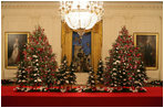 The White House has a total of 17 decorated Christmas trees. Two are placed next to the famous portraits of George and Martha Washington in the East Room. They are trimmed with silvered-glass ornaments painted in red and fuchsia. Between them, recessed in the wall is an elaborate nativity scene.