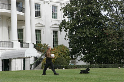 Barney leads the way as President George W. Bush carries Barney’s favorite soccer ball out to play on the South Lawn of the White House, Sunday, Nov. 25, 2007.