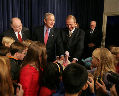 President George W. Bush invites children on stage, Tuesday, November 22, 2005, to pet "Marshmallow", the National Thanksgiving Turkey, at the official pardoning of the turkey at the Eisenhower Executive Office Building in Washington.
