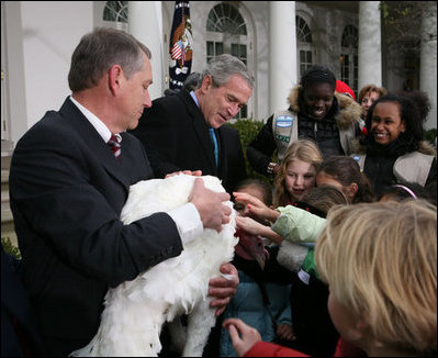 President George W. Bush invites children to meet “Flyer” the turkey, held by Lynn Nutt of Springfield, Mo., during a ceremony Wednesday, Nov. 22, 2006 in the White House Rose Garden, following the President’s pardoning of the turkey before the Thanksgiving holiday.