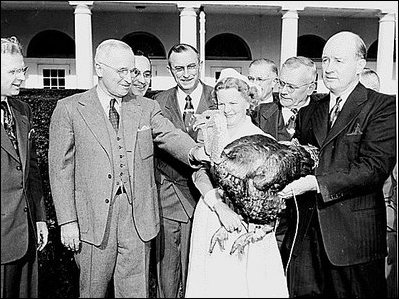 Photograph of President Truman receiving a Thanksgiving turkey from members of the Poultry and Egg National Board and other representatives of the turkey industry,outside the White House. 
